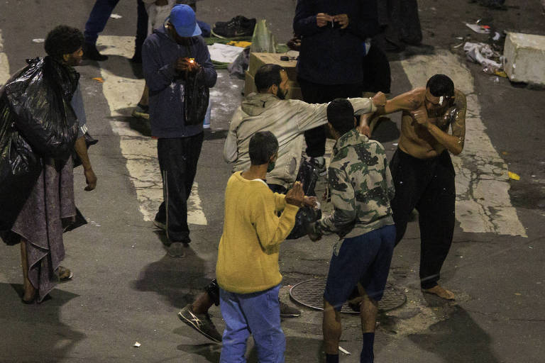 Na foto, duas pessoas presentes no fluxo brigam na rua General Rondon