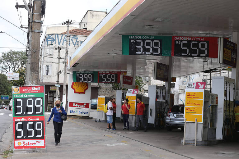 Foto mostra um posto de gasolina com cartazes indicando novos preços dos combustíveis