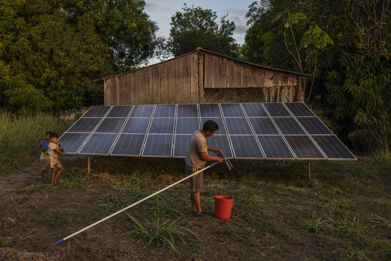 O indígena Towayanin Kaiabi, conhecido como Velhinho, limpa placas solares que abastecem o polo Diauarum, no Xingu