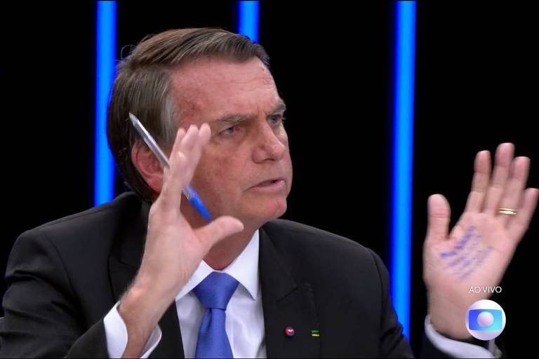 Bolsonaro repete 2018 e leva 'cola' na mão para entrevista ao JN