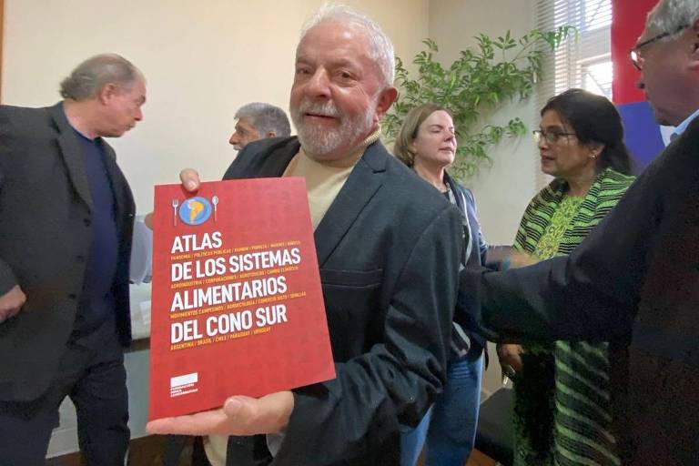 O ex-presidente Lula com atlas que ganhou sobre combate à fome após visita de dirigentes da esquerda alemã