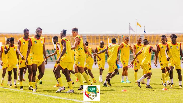 Vestidos com uniforme amarelo, jogadores da seleção de futebol do Benin participam de treino