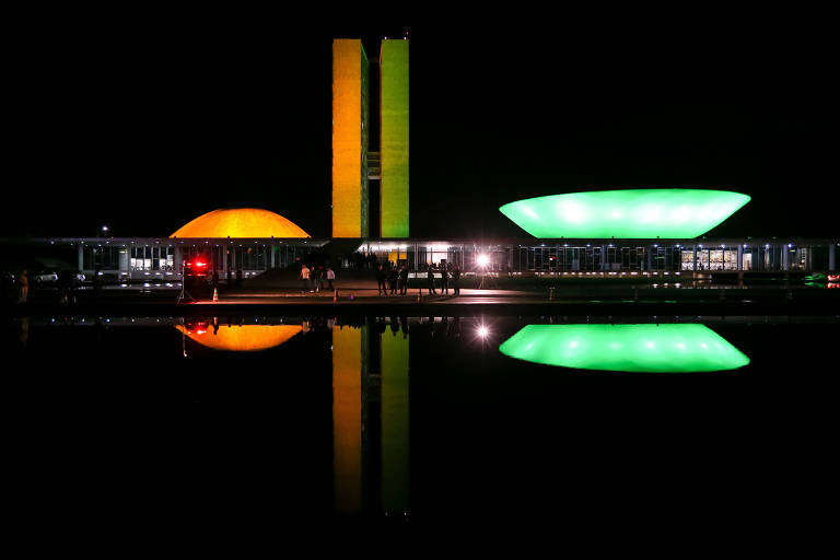 Fachada do Congresso Nacional, iluminada com as cores do Brasil