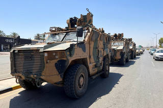 Military vehicles of the Libyan armed unit prepare to enter the area of clashed in Tripoli