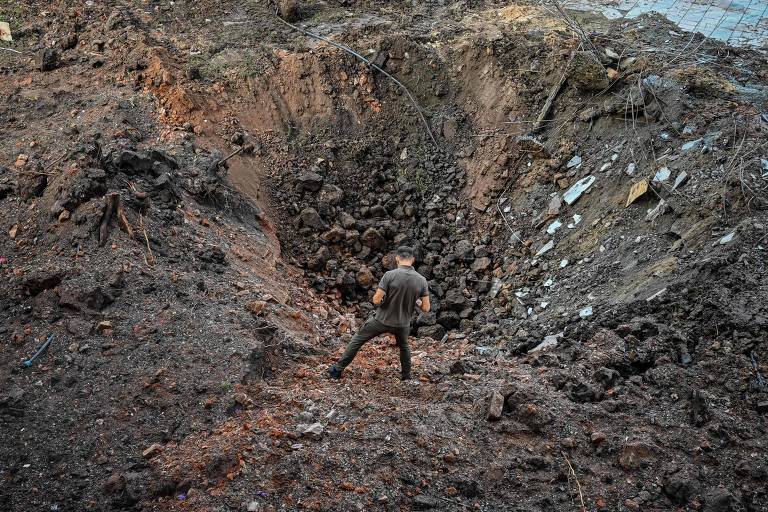 Militar ucraniano examina cratera causada por míssil russo em ataque a Kharkiv