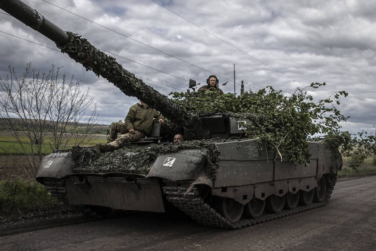 Soldados ucranianos pilotam tanque com camuflagem