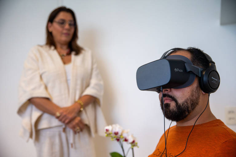 A psicóloga Juliane Verdi Haddad (à esquerda) realiza uma simulação de uma sessão de terapia contra fobia com realidade virtual com o seu paciente, Francisco Nascimento (à direita) 