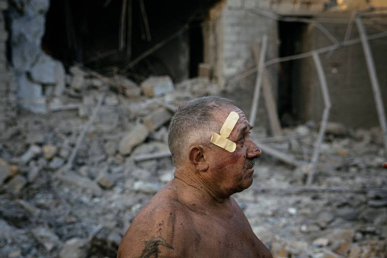 O morador Okesandr Chulga olha sua casa destruída por um ataque russo em Mikolaiv