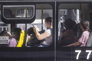 ***Especial  30 anos de Privatizacoes.: TELEFONIA: Passageira de onibus usa celular em linha na av Paulista