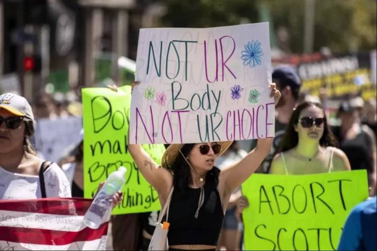 Mulheres com cartazes protestam contra a revogação da decisão do caso Roe x Wade, que garantia o direito ao aborto nos EUA