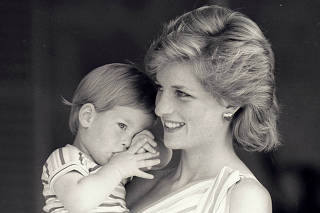 FILE PHOTO: Young Prince Harry tries to hide behind his mother Diana, Princess of Wales