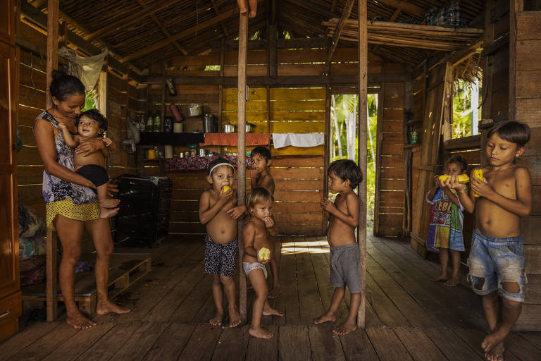 Lidiane de Lima Gomes, 25, com seus filhos no interior de sua casa, na zona rural de Melgaço, onde foram instaladas placas solares fotovoltaicas