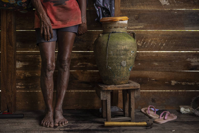Benedita Duarte, 54, ao lado de um pote usado para armazenar água no interior de sua casa, em Melgaço; recentemente ela passou a contar com energia solar em casa
