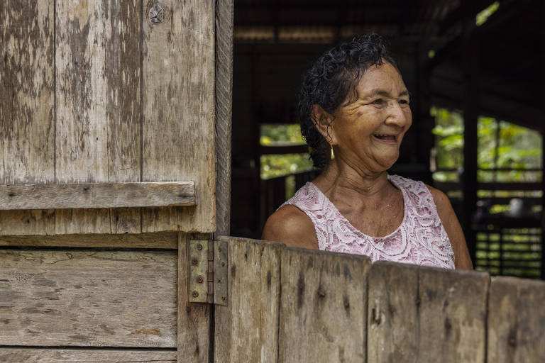 Mulher sorri em uma casa de madeira