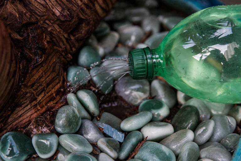 Água saindo por furos em tampa de garrafa pet verde
