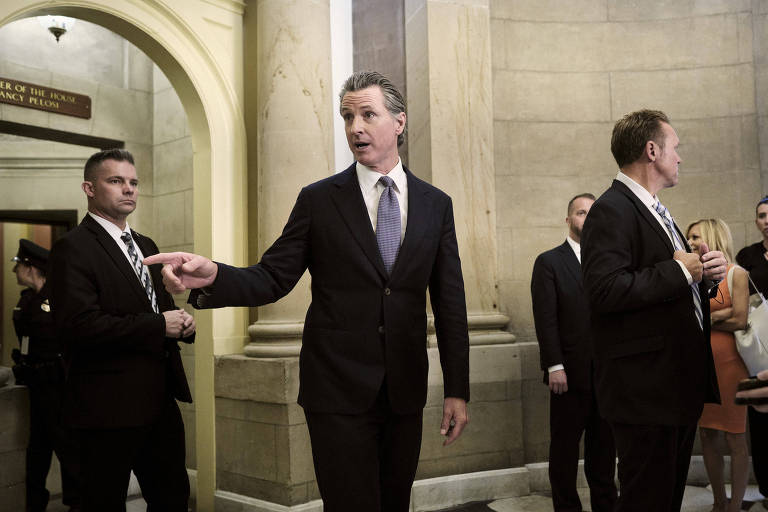 O governador da Califórnia, Gavin Newson, acena ao entrar no Capiólio, durante visita em Washington