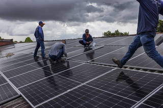 Operários instalam painéis solares no telhado do Sex Motel, em Boa Vista (RR) 