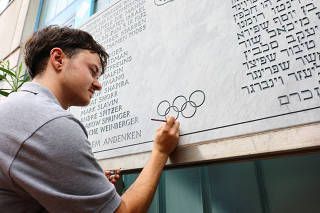 A stone cutter renovates a memorial stone for the 11 Israeli athletes killed by Palestinian militants during the 1972 Olympic Games