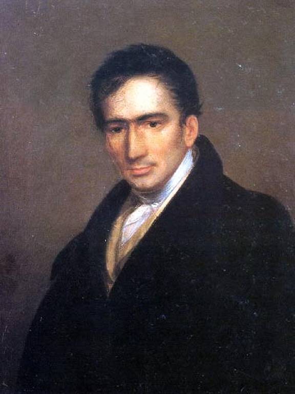 retrato de chalaça, um homem branco de cabelos curtos pretos. ele usa um sobretudo preto sobre uma camisa branca