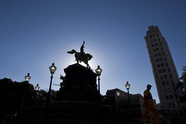 estátua de dom pedro 1º sobre o cavalo, em foto contra o sol, de modo que só aparece a silhueta do imperador contra o céu azul
