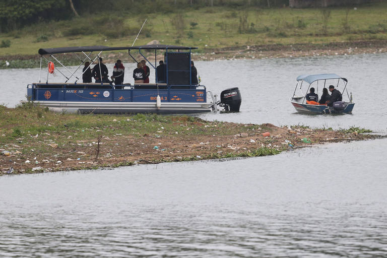 Barco com oficiais da Policia Civil e um suspeito da morte do ambientalista Adolfo Souza Duarte navega pela represa Billings seguido por um barco inflável dos bombeiros