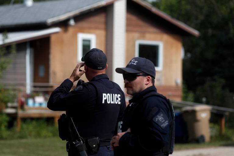 Policiais fazem operação em frente à casa onde uma das vítimas do esfaqueamento foi encontrada em Weldon, no Canadá
