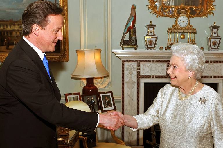 Elizabeth 2ª cumprimenta o primeiro-ministro David Cameron durante encontro no Palácio de Buckingham, em Londres