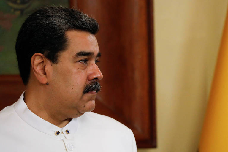 Vestindo uma camisa branca, o presidente da Venezuela, Nicolás Maduro, é retratado de perfil no Palácio de Miraflores, a sede de seu governo, em Caracas; ele usa bigode e está com o semblante sério