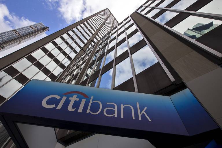 Prédio de fachada espelhada, com um painel azul em que se lê Citibank, em branco.