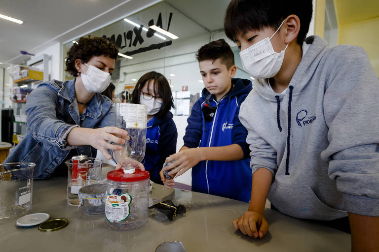 Na foto, quatro estudantes do Centro Educacional Pioneiro, na zona sul de SP, testam protótipo de cisterna feito com garrafas PET e outros materiais recicláveis