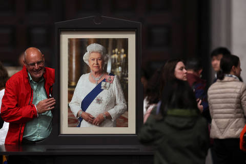 A man poses next to a picture of the Queen after participating in a Service of Prayer and Reflection, following the passing of Britain's Queen Elizabeth, at St Paul's Cathedral in London, Britain September 9, 2022. REUTERS/Paul Childs/Pool ORG XMIT: BLR
