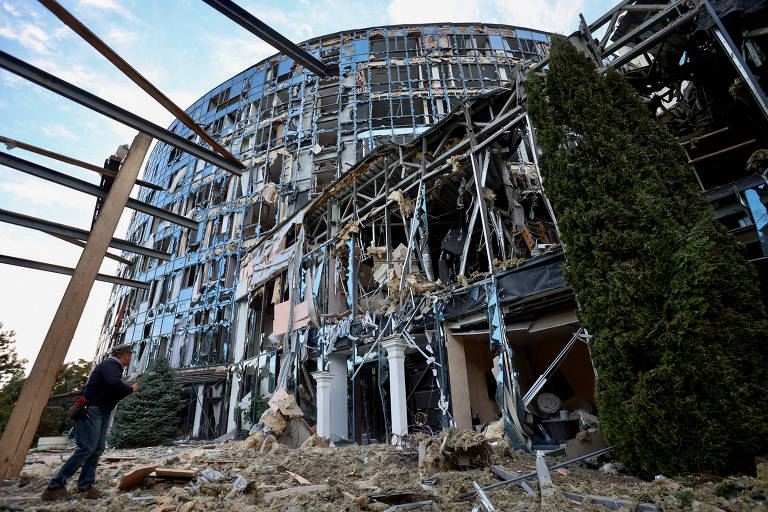 Homem observa prédios atingidos em ataque militar russo a Kharkiv, na Ucrânia