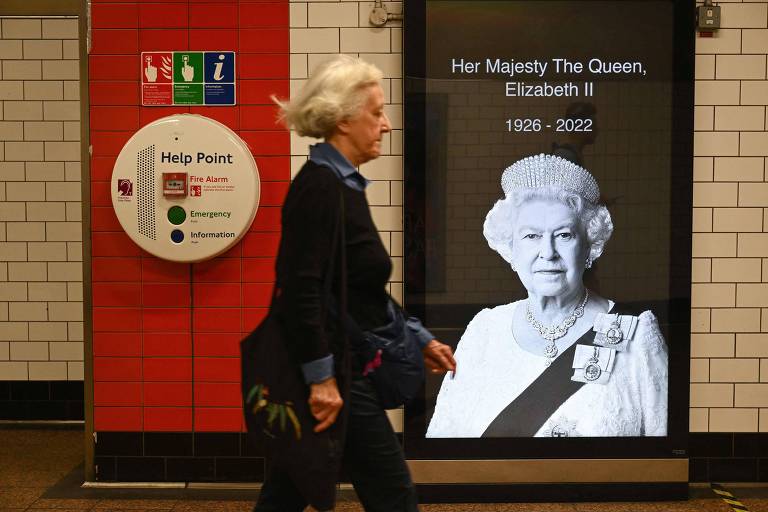 Mulher passa por imagem da rainha Elizabeth 2ª no metrô de Londres neste sábado (10), dois dias após a morte da monarca