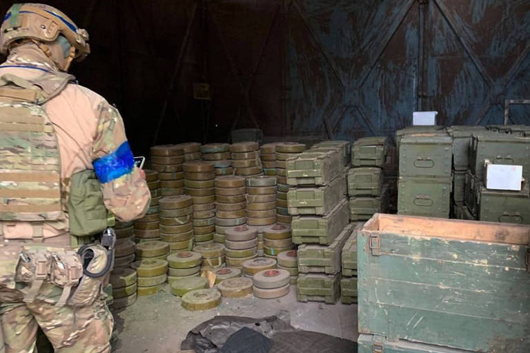 Soldado ucraniano em um suposto depósito de munição deixado para trás pelos russos em Izium