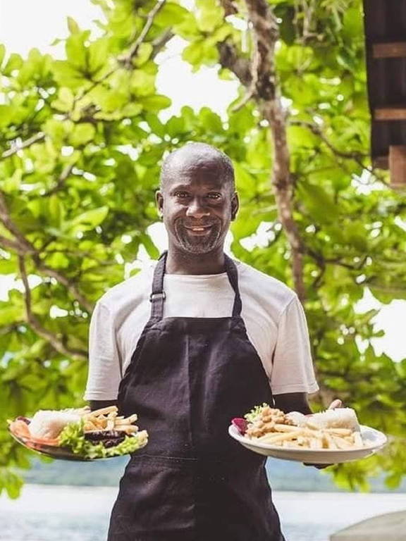 retrato de homem negro com aventual segurando dois pratos