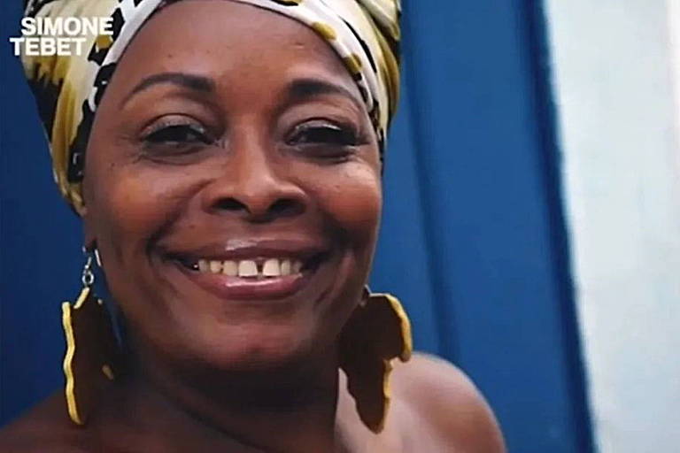 retrato de mulher negra com turbante e brincos no formato da África