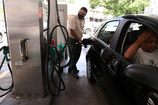 FILE PHOTO: A worker pumps a car with gasoline at a gas station in Rio de Janeiro