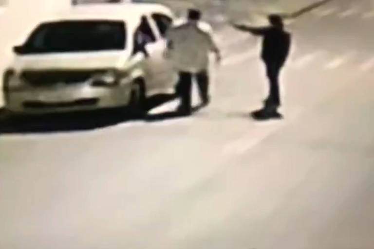 imagem de câmera de segurança mostra homem apontando arma na cabeça de outro