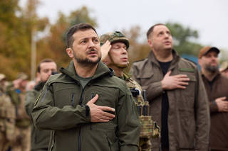 Ukraine's President Zelenskiy sings a national anthem during a flag rising ceremony in the town of Izium