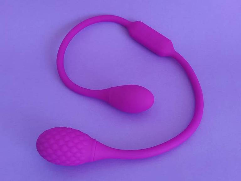 Imagem mostra vibrador duplo na cor lilás; produto é composto por uma corda flexível que une dois bullets
