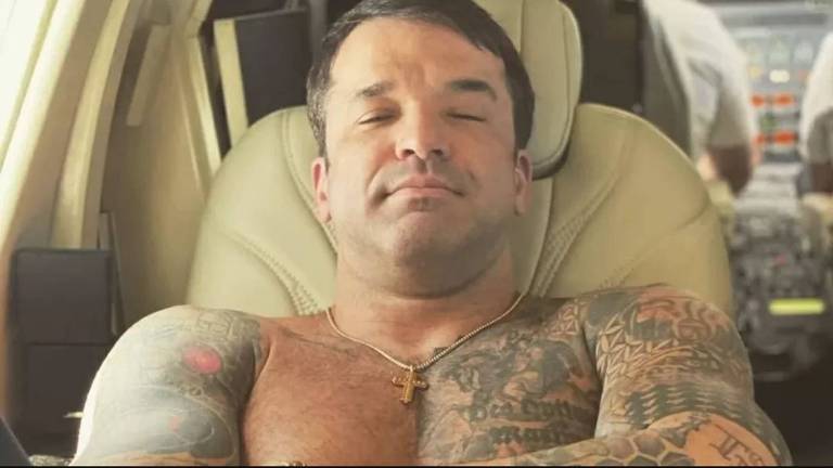 Foto do empresário Thiago Brennand sem camisa, deitando em uma bancada