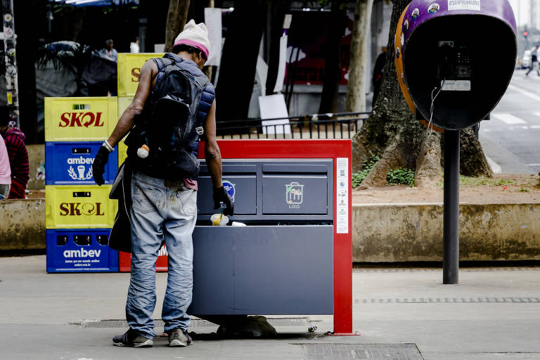 Homem mexe em lixeira na Avenida Paulista, região central de São Paulo; reportagem da Folha e da Agência Mural percorreu bairros da capital e Grande São Paulo e viu pessoas pedindo dinheiro ou doação de alimentos, outras que buscavam reaproveitar restos que não foram vendidos na feira e moradores em situação de rua procurando comida em lixeiras