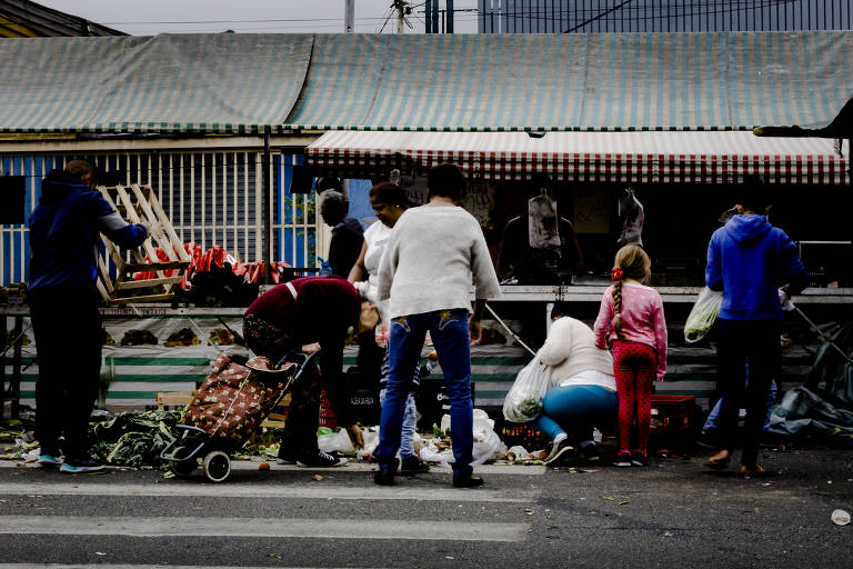Pessoas buscam por restos em feira no Jaçanã, zona norte de São Paulo; reportagem da Folha e da Agência Mural percorreu bairros da capital e Grande São Paulo e viu pessoas pedindo dinheiro ou doação de alimentos, outras que buscavam reaproveitar restos que não foram vendidos na feira e moradores em situação de rua procurando comida em lixeiras