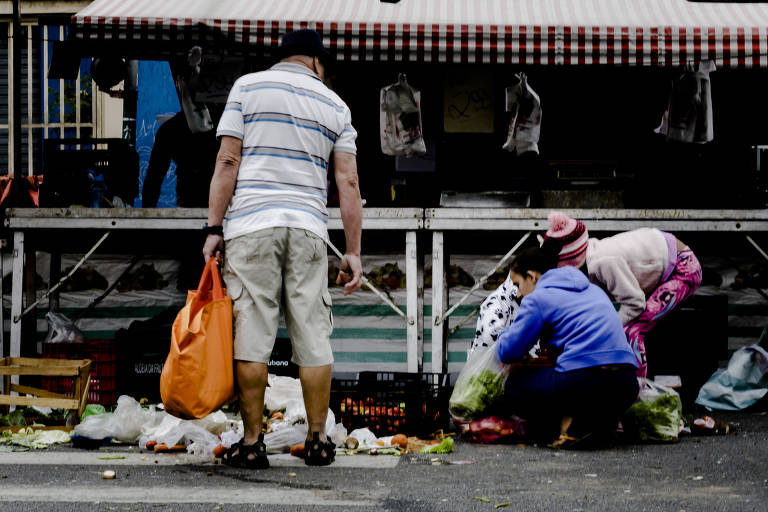 Pessoas buscam por restos em feira no Jaçanã, zona norte de São Paulo; reportagem da Folha e da Agência Mural percorreu bairros da capital e Grande São Paulo e viu pessoas pedindo dinheiro ou doação de alimentos, outras que buscavam reaproveitar restos que não foram vendidos na feira e moradores em situação de rua procurando comida em lixeiras