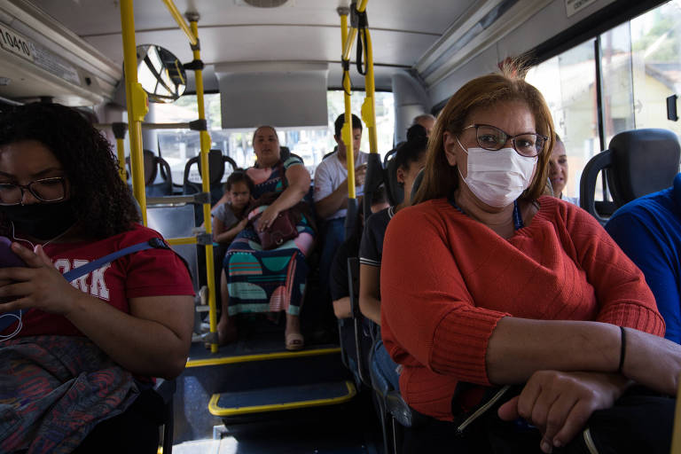 mulher de máscara em ônibus