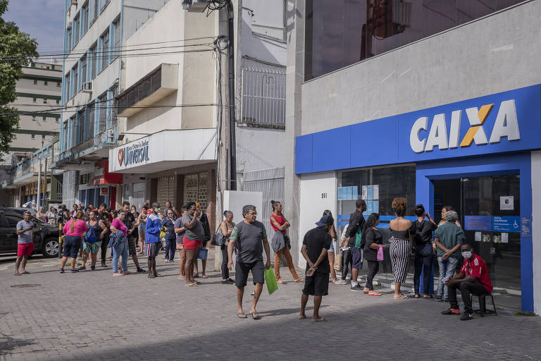 Imagem mostra entrada de uma agência da Caixa Econômica Federal localizada em Bonsucesso, zona norte do Rio de Janeiro. Uma fila de correntistas aguarda para entrar na unidade do banco.