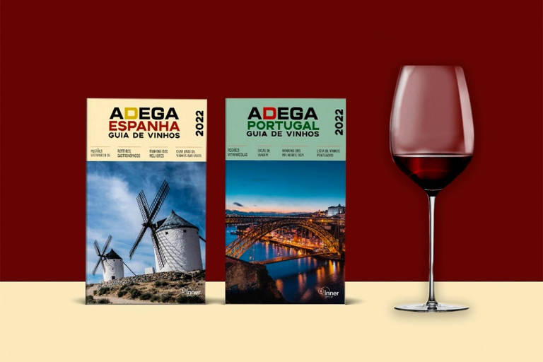 Na foto, dois livros sobre vinho onde se lê Adega Espanha e Adega Portugal. Ao lado, uma taça de vinho tinto