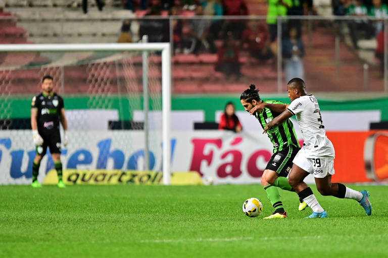 Benítez, do América-MG, disputa a bola com Raul Gustavo, do Corinthians, em partida na noite deste domingo (18)
