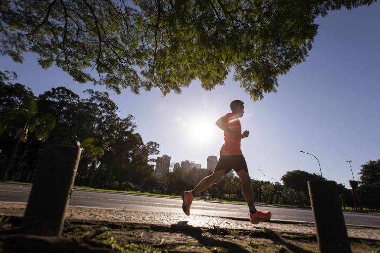Homem corre na rua ao lado do parque Ibirapuera.