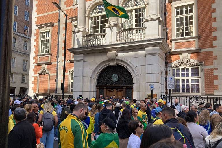 Apoiadores de verde e amarelo recebem o presidente Jair Bolsonaro em frente à Embaixada do Brasil em Londres